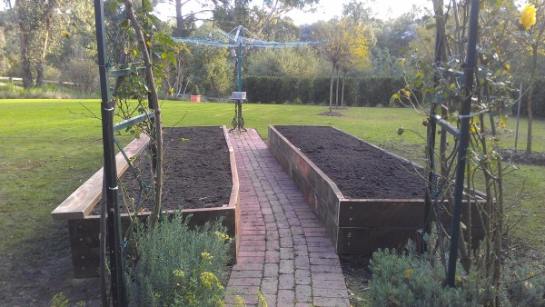 curved ironbark veggie beds along path to clothes line by Yummy Gardens Melbourne